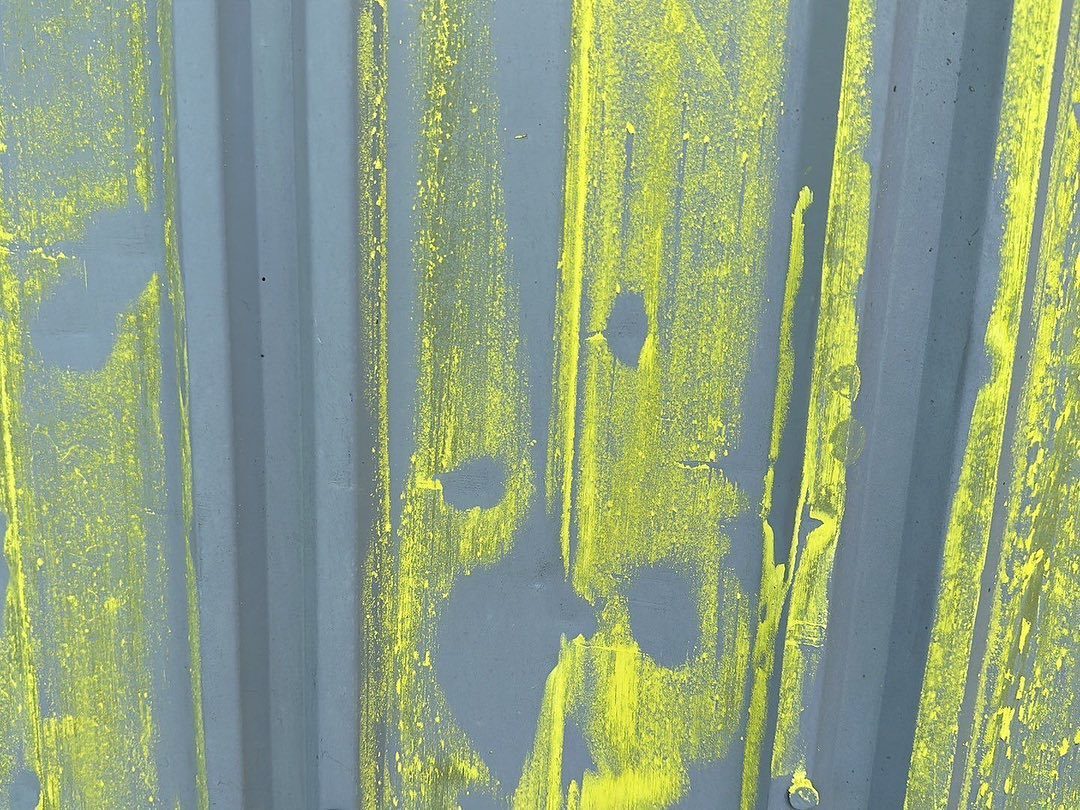 Hail dents on a metal panel, marked so they show up in photos.